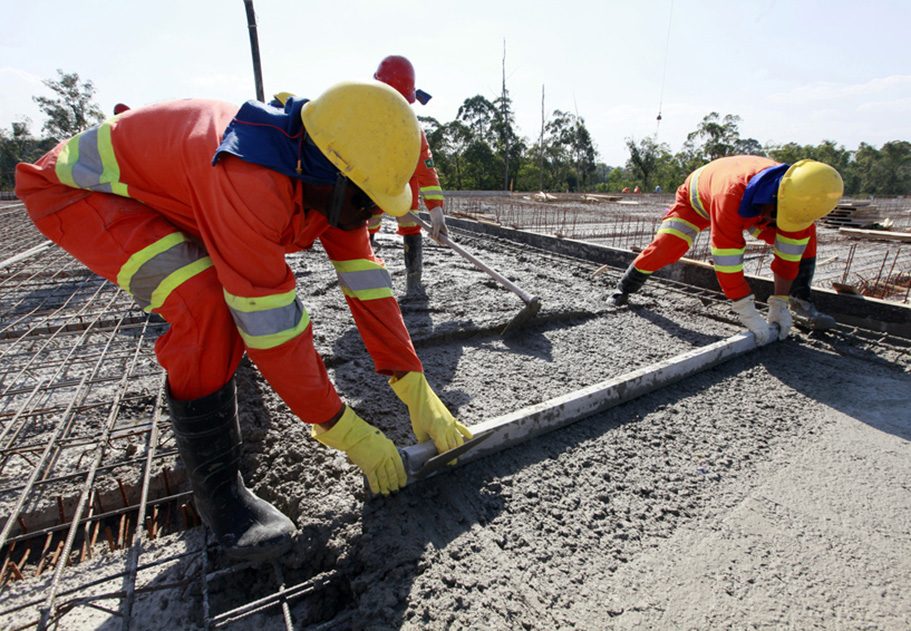 workers pouring cement in road construction on brazil